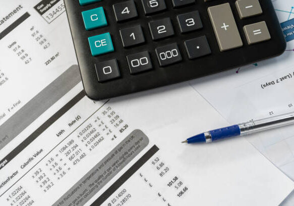 Concept of paying bills. Close up cropped photo with flat lay high angle above top view of object blank calculator and pen